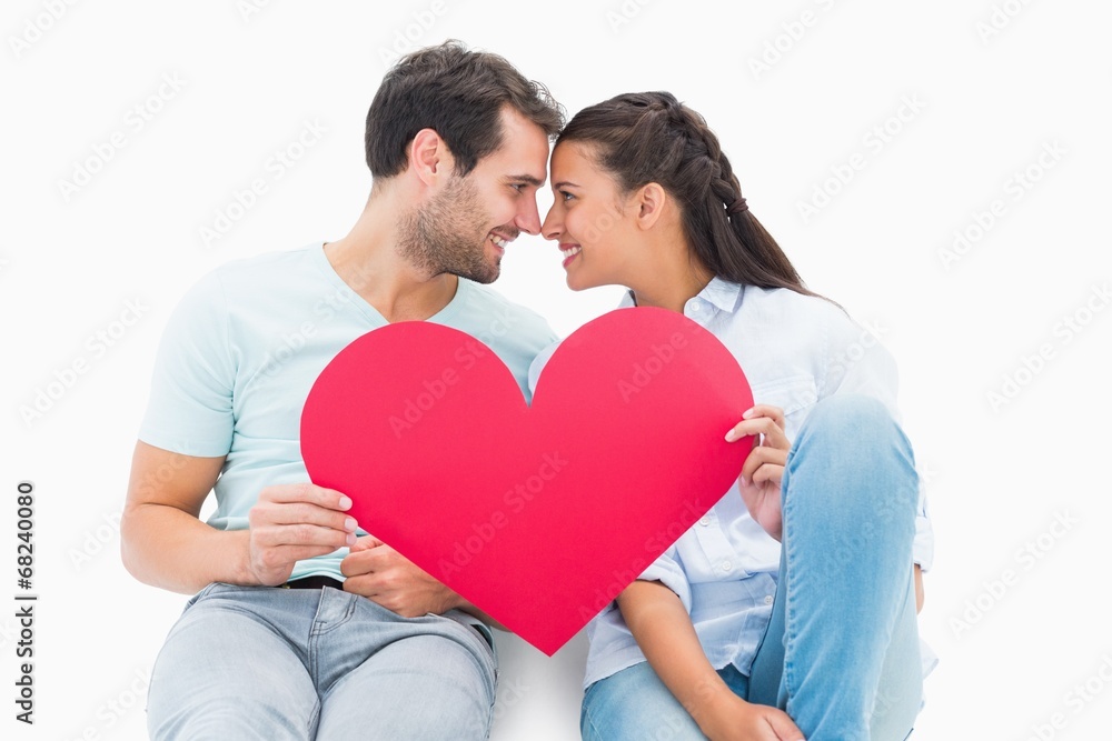 Cute couple sitting holding red heart