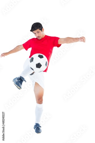 Football player in red kicking ball © WavebreakMediaMicro