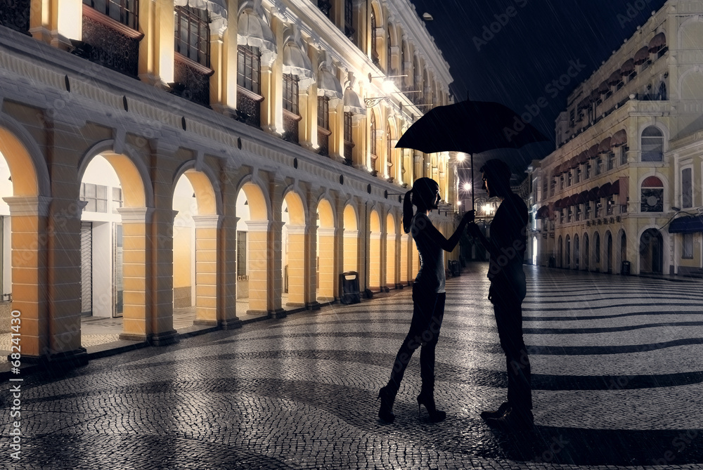 Couple standing in the raining street