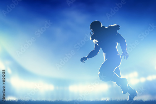 American football players in game, running. Stadium lights