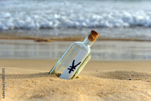 Yen, currency of Japan in a bottle on the beach