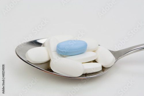 Loeffel mit weissen und einer blauen Pille