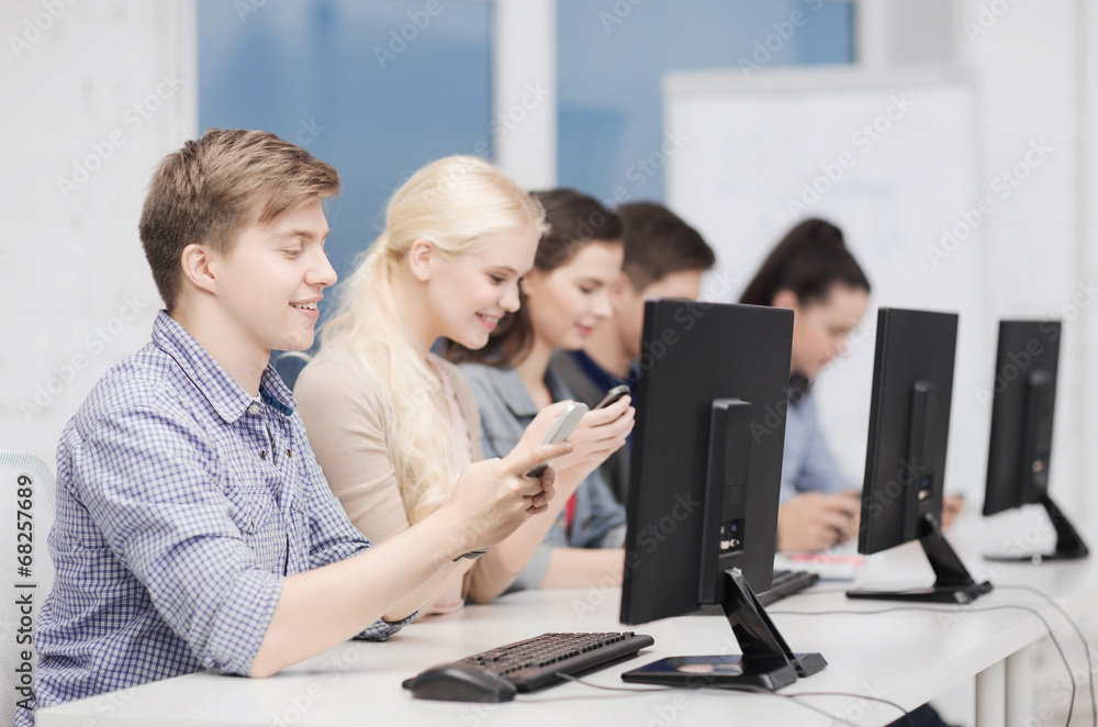 students with computer monitor and smartphones students with computer monitor and smartphones