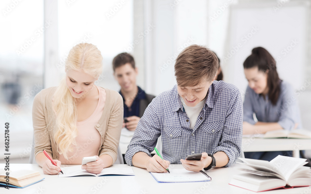 students looking into smartphone at school students looking into smartphone at school