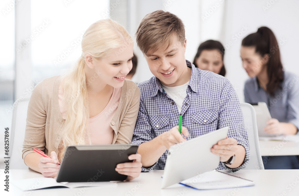 two smiling students with tablet pc and notebooks two smiling students with tablet pc and notebooks
