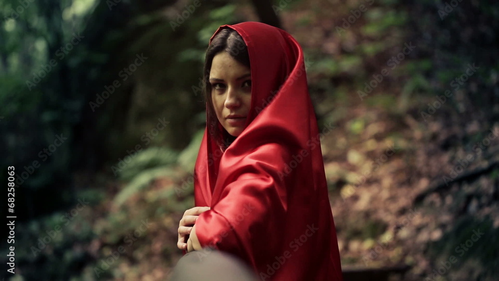 Serious beautiful mysterious woman, red riding hood in forest Serious beautiful mysterious woman, red riding hood in forest
