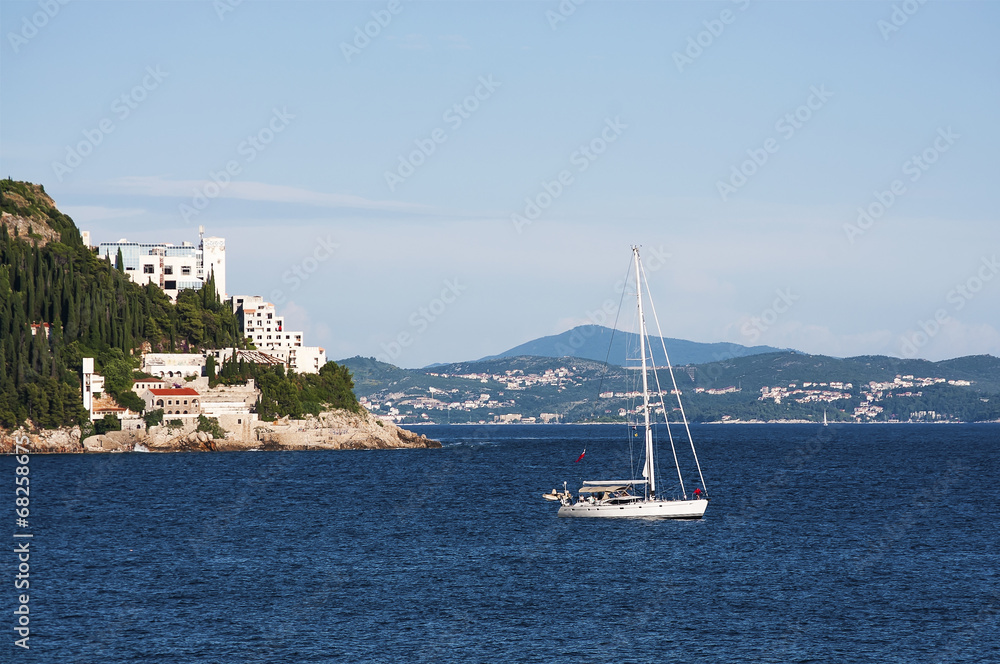 Yacht in the sea with beautiful village on background
