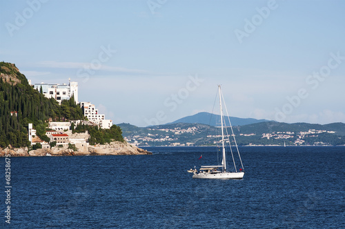 Yacht in the sea with beautiful village on background