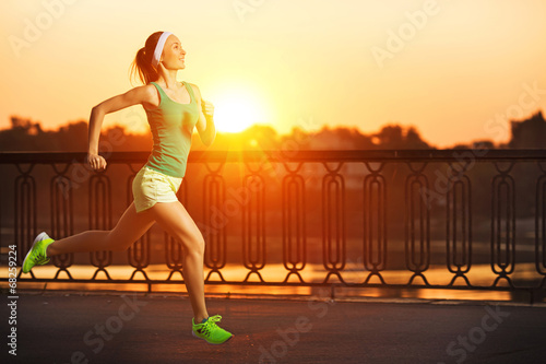 Running woman. Runner is jogging on sunrise. Female fitness