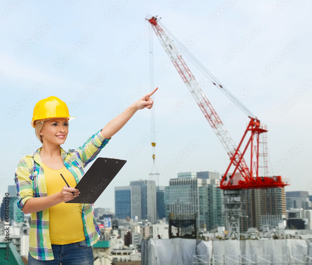 smiling woman in helmet with clipboard smiling woman in helmet with clipboard