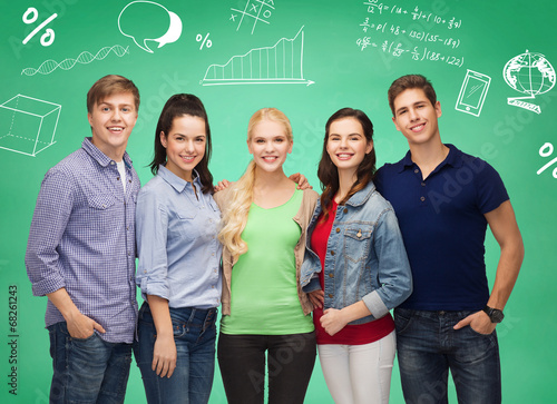 group of smiling students over green board
