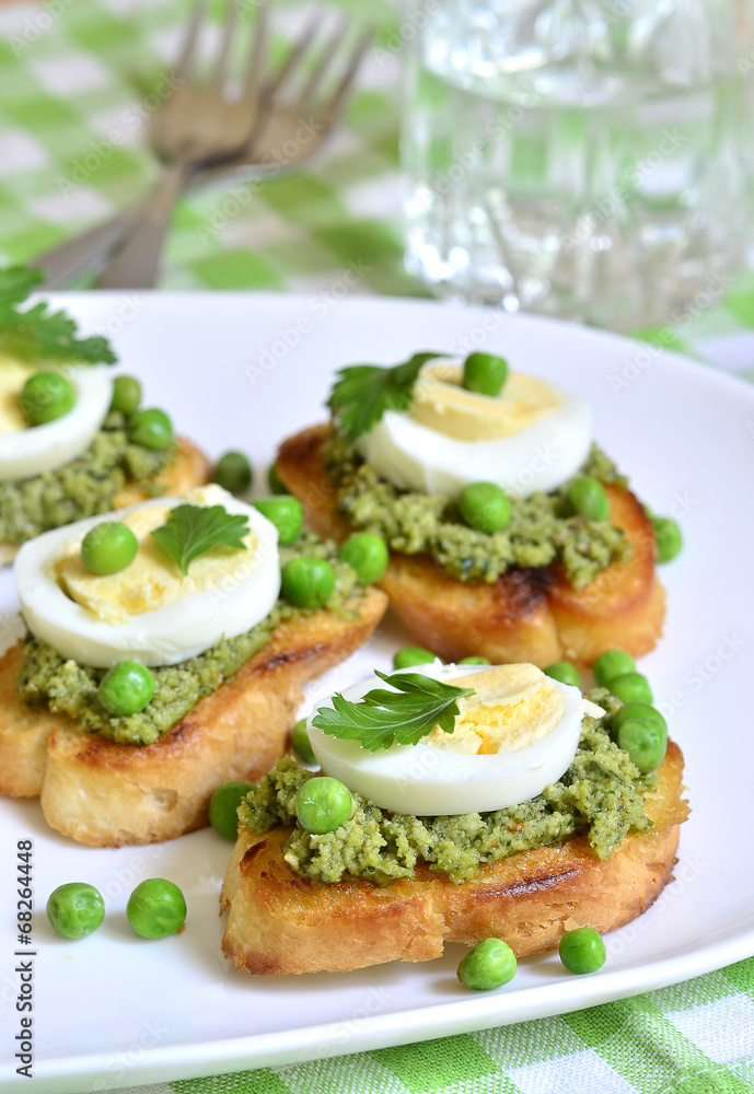 Toasts with basil pesto,eggs and green peas.