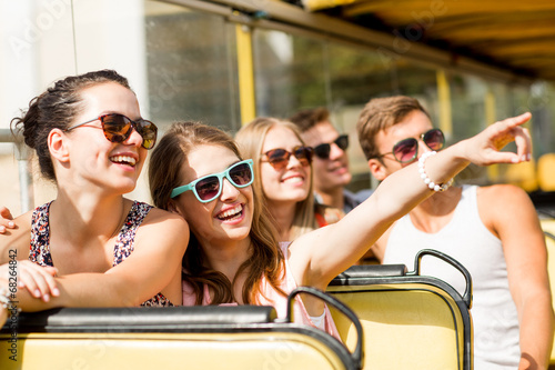 Картината върху платно group of smiling friends traveling by tour bus