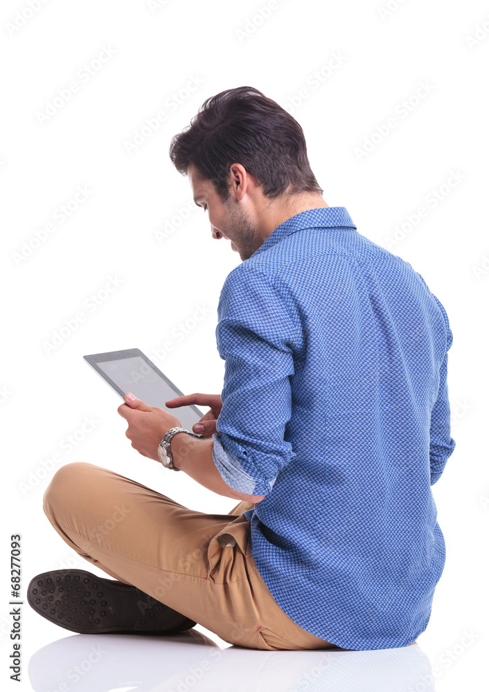 side back view of a man working on tablet computer side back view of a man working on tablet computer