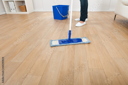 Woman Mopping Hardwood Floor At Home