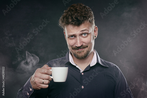 Handsome beard man stand in fog with cup of coffee in his hand