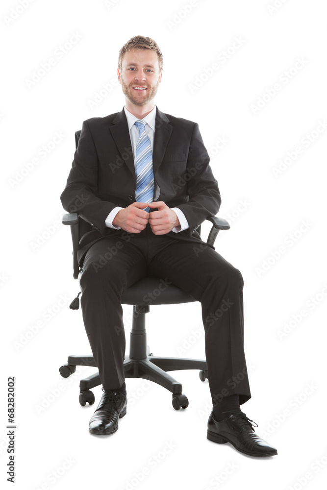 Confident Businessman Sitting On Office Chair Confident Businessman Sitting On Office Chair
