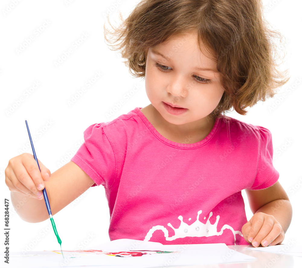 Little girl is painting with gouache