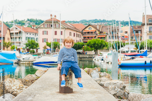 Outdoor portrait of a cute toddler boy in a small beautiful port © annanahabed