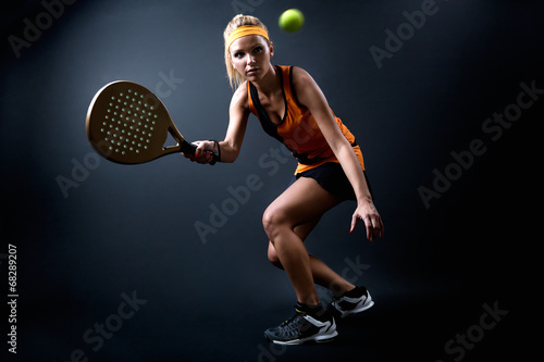 Obraz na plátně Beautiful woman playing padel indoor. Isolated on black.