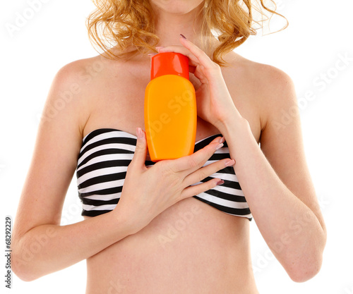 Young woman in swimsuit holding spray tanning isolated on white
