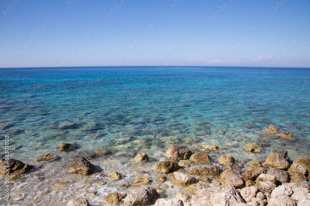 Steiniger Strand mit blauem Wasser und Blick zum Horizont