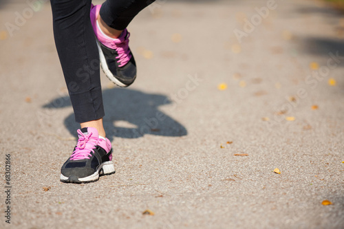 Runner feet running on road closeup on shoe