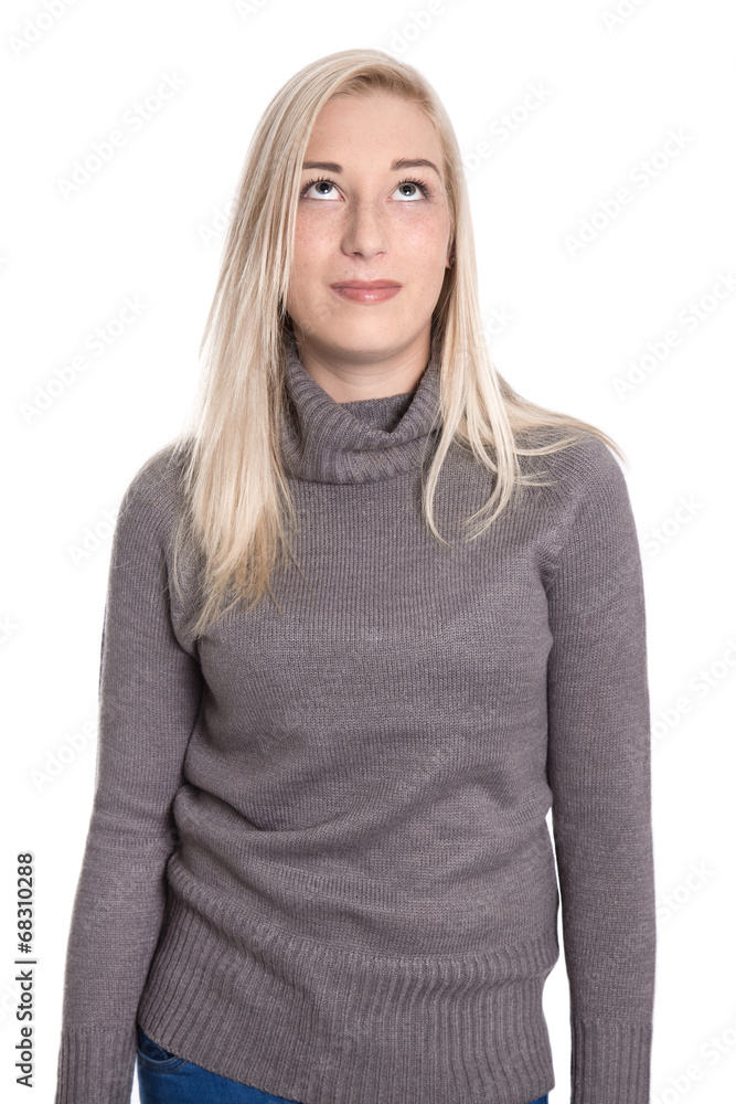 Junge blonde Frau isoliert in Pullover blickt nach oben