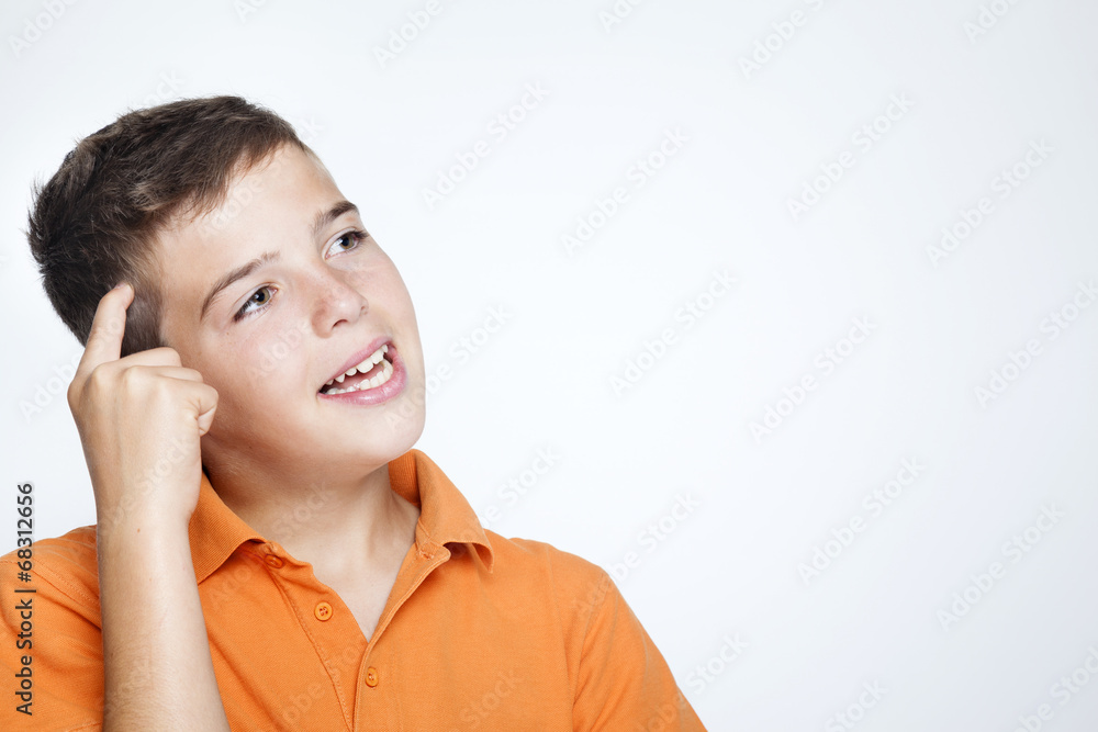 Closeup of a teenager boy thinking about something against gray