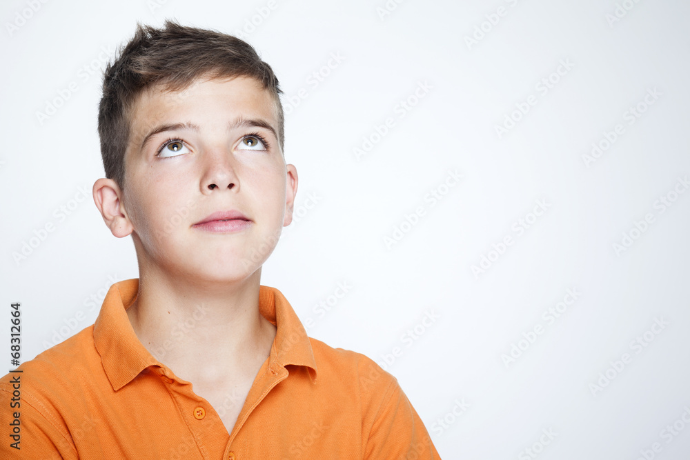 Closeup of a teenager boy looking up against gray background Closeup of a teenager boy looking up against gray background