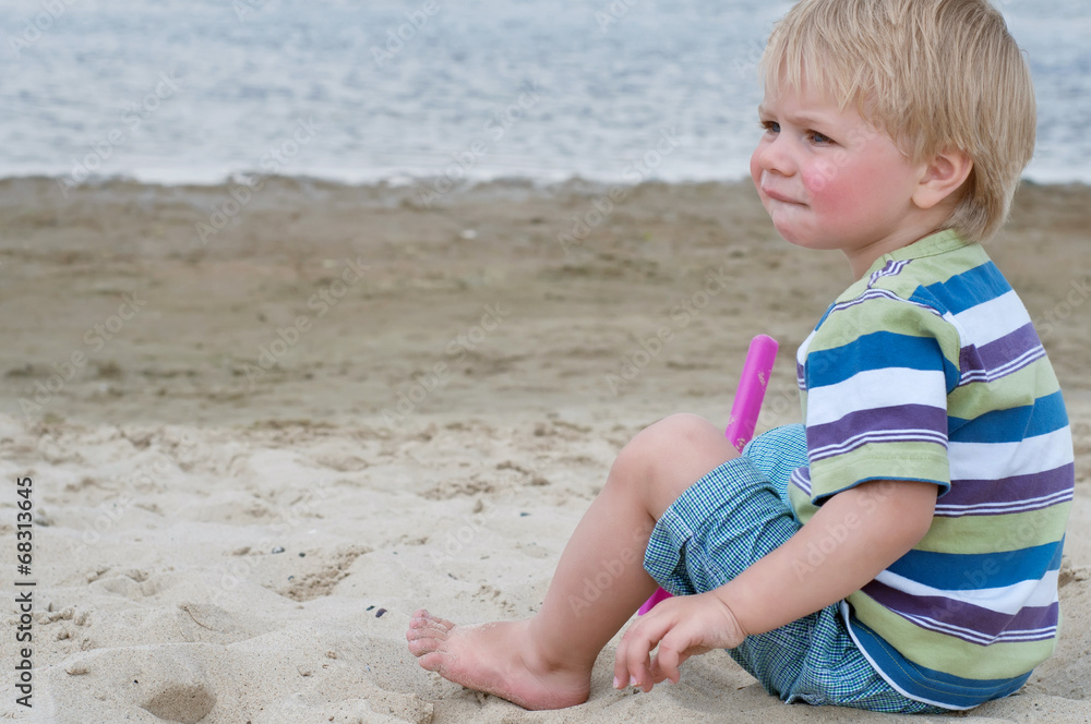 Little toddler boy sitting on sand beach Little toddler boy sitting on sand beach