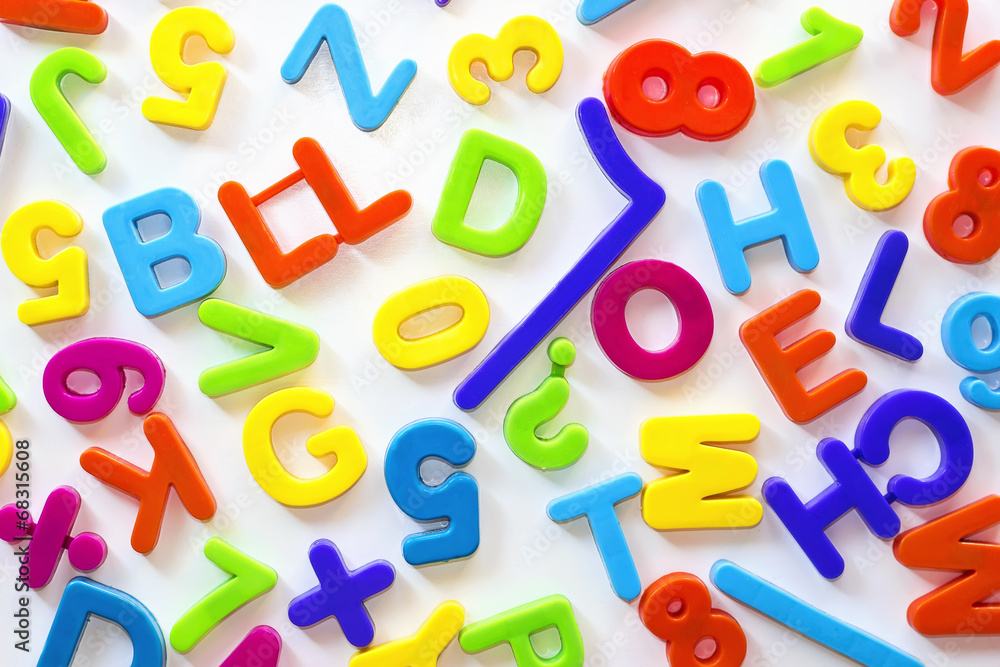 Fototapeta premium Letras y números de distintos colores sobre superficie blanca