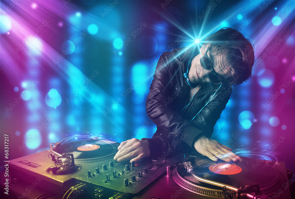 Obraz premium Dj mixing music in a club with blue and purple lights