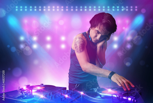 Disc jockey mixing music on turntables on stage with lights and © ra2 studio