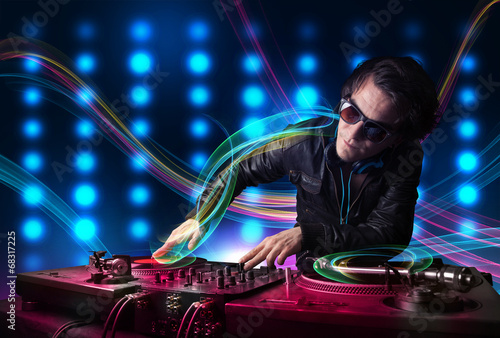 Young Dj mixing records with colorful lights photo