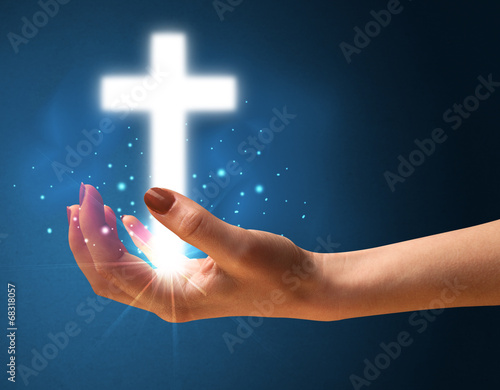 Fototapeta Naklejka Na Ścianę i Meble -  Glowing cross in the hand of a woman