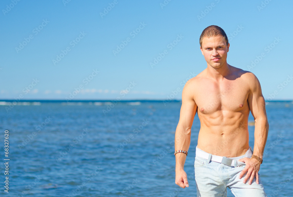 Muscular attractive man posing near the sea. Muscular attractive man posing near the sea.