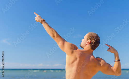 Muscular attractive man posing near the sea. © M-Production