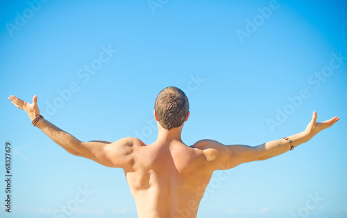 Muscular attractive man near the sea. Freedom concept.