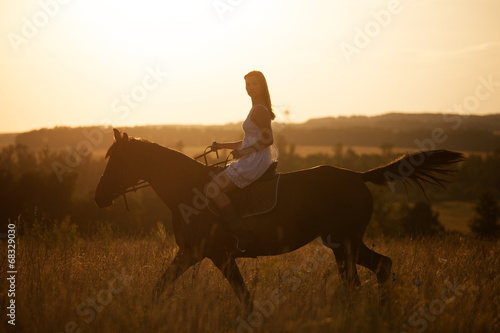 Girl on a horse at sunset