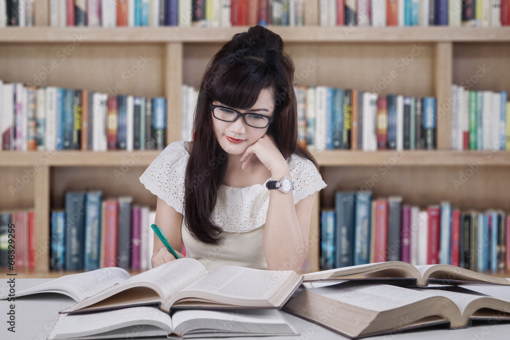 Beautiful student studying in the library Beautiful student studying in the library
