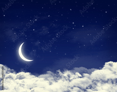 Moon and stars in a cloudy night blue sky