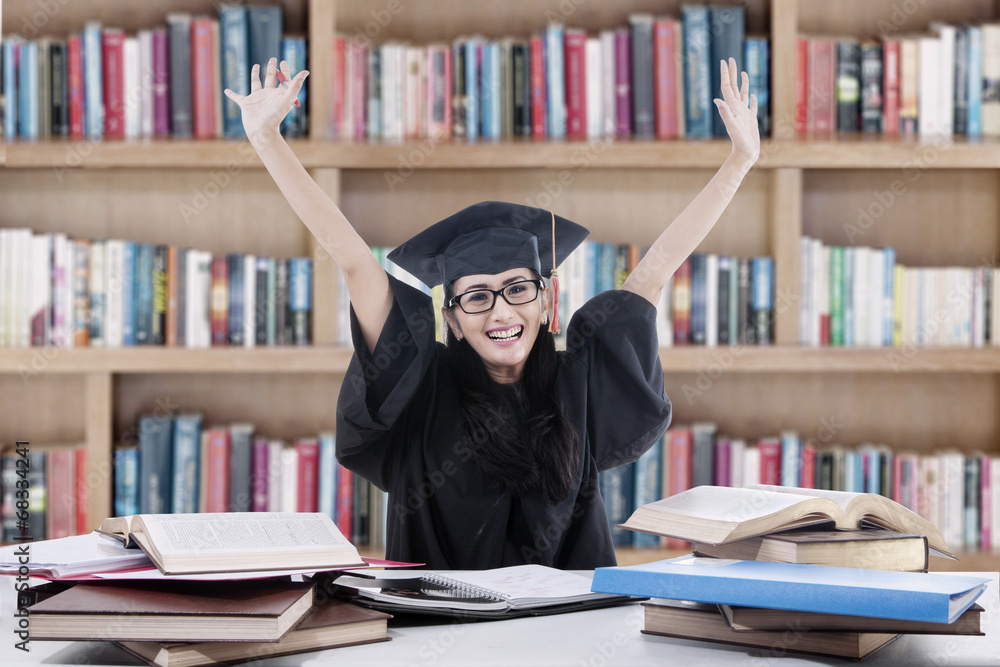 Excited bachelor studying in library Excited bachelor studying in library