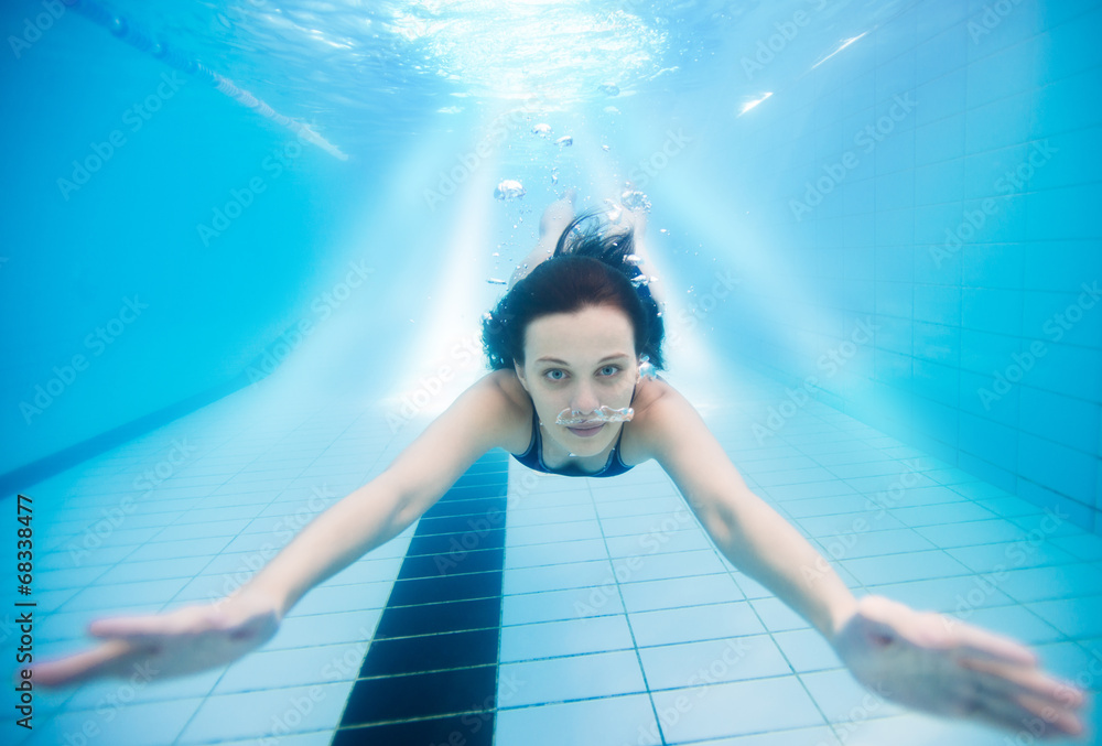 Fototapeta premium Woman swimming underwater in pool
