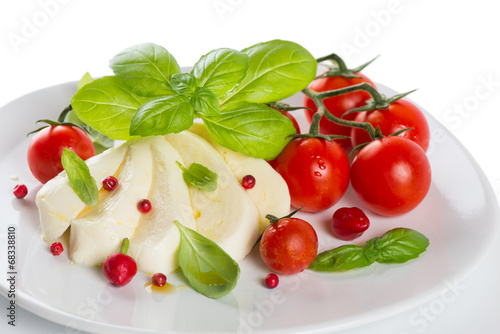 mozzarella cherry tomatoes basil on a white plate