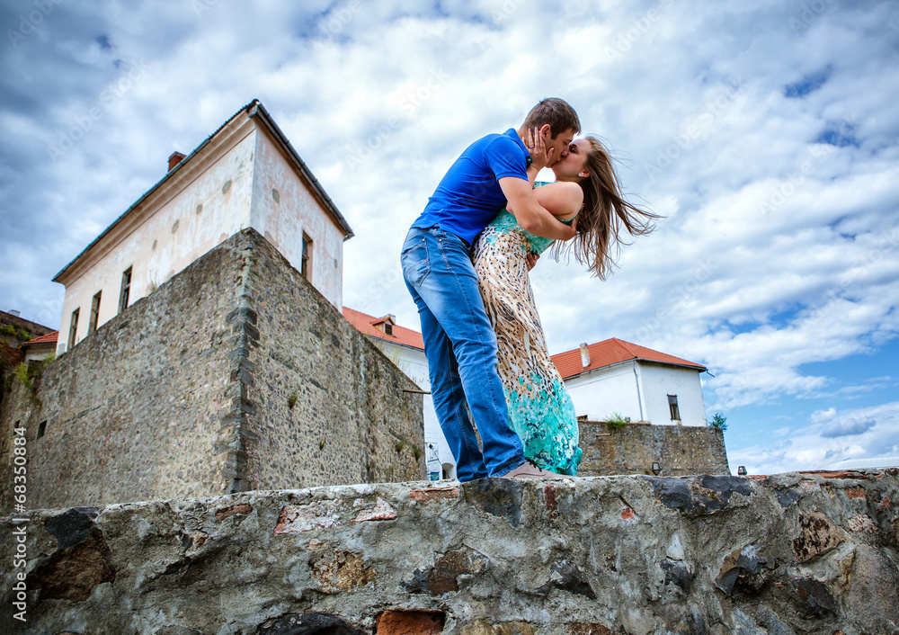 Fototapeta premium guy kissing the girlfriend against the old lock