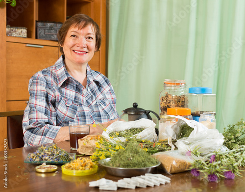 Mature woman with herbs at table