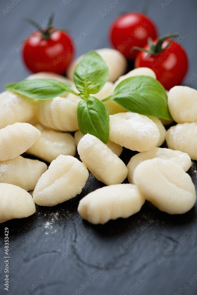 Close-up of raw gnocchi with red cherry tomatoes and green basil Close-up of raw gnocchi with red cherry tomatoes and green basil