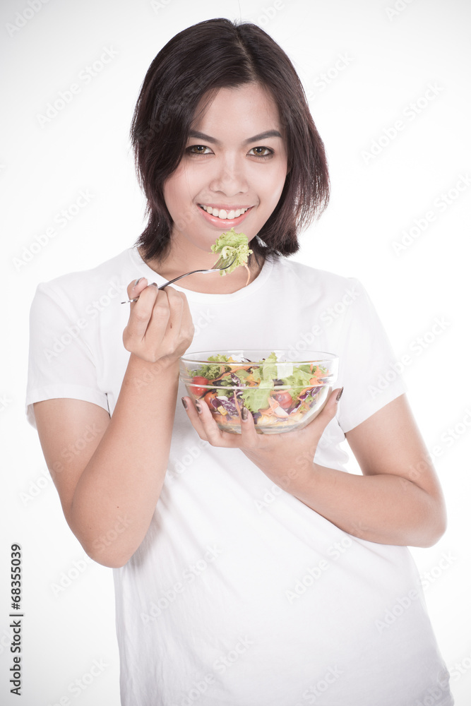 Pretty girl eating fresh vegetable salad