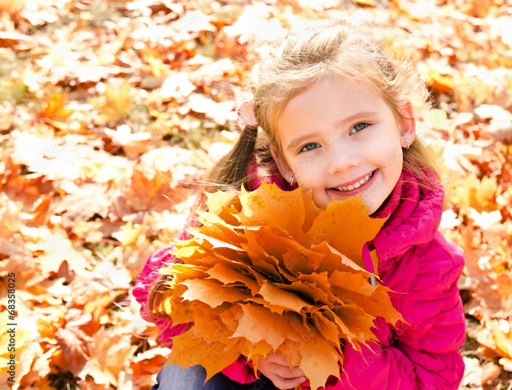 Autumn portrait of cute smiling little girl with maple leaves Autumn portrait of cute smiling little girl with maple leaves
